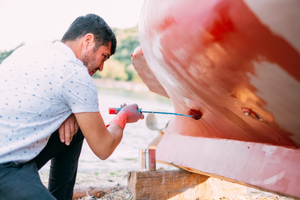 Personne faisant de la peinture pour son bateau