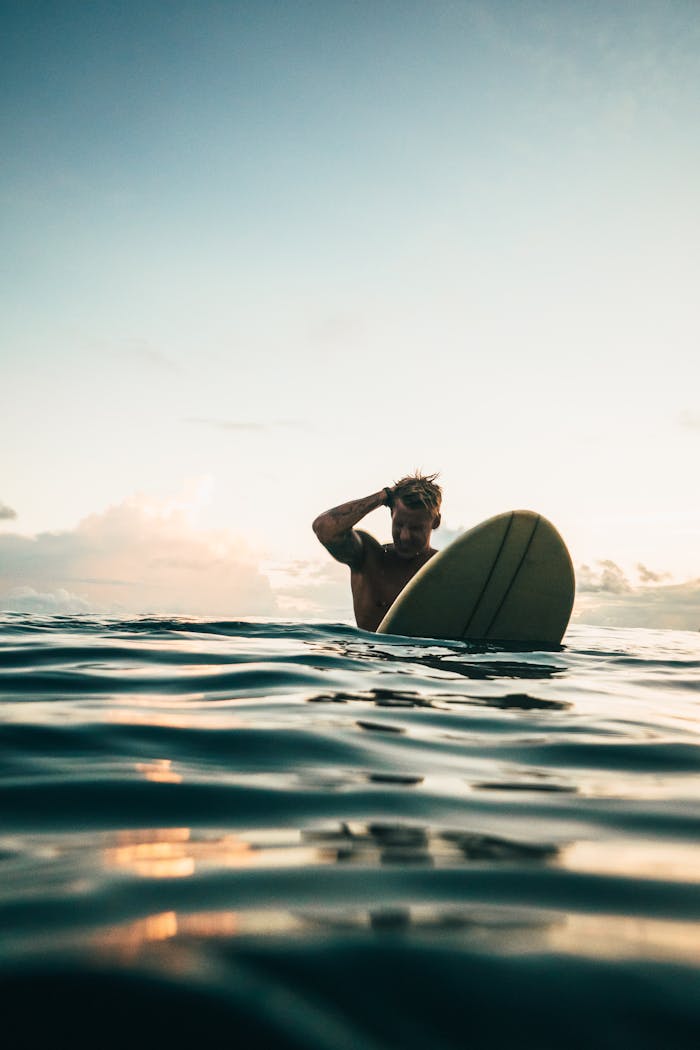 services-02 A surfer enjoys the serene waters and a stunning sunset on the coast of Indonesia, perfect for adventurers.